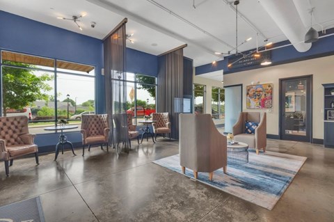 A spacious waiting area with blue walls and brown chairs.