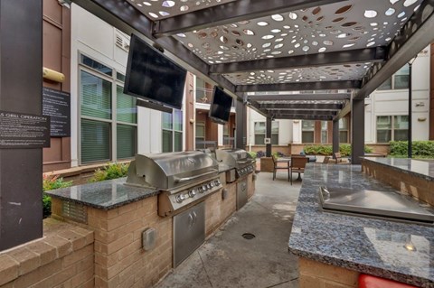 A patio with a grill and a flat screen TV.