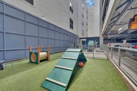 A playground area with a green slide and a basketball hoop.