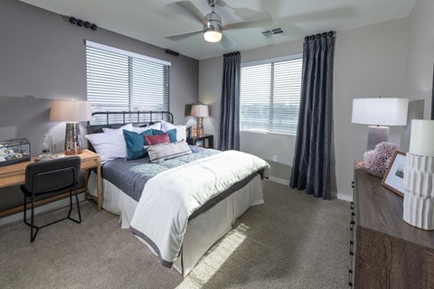 a bedroom with a bed and two windows
