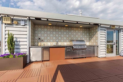 A patio with a grill and a wallpapered wall.