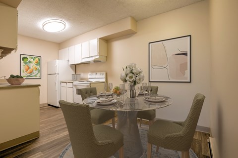 A dining room with a table set for two and a framed picture on the wall.
