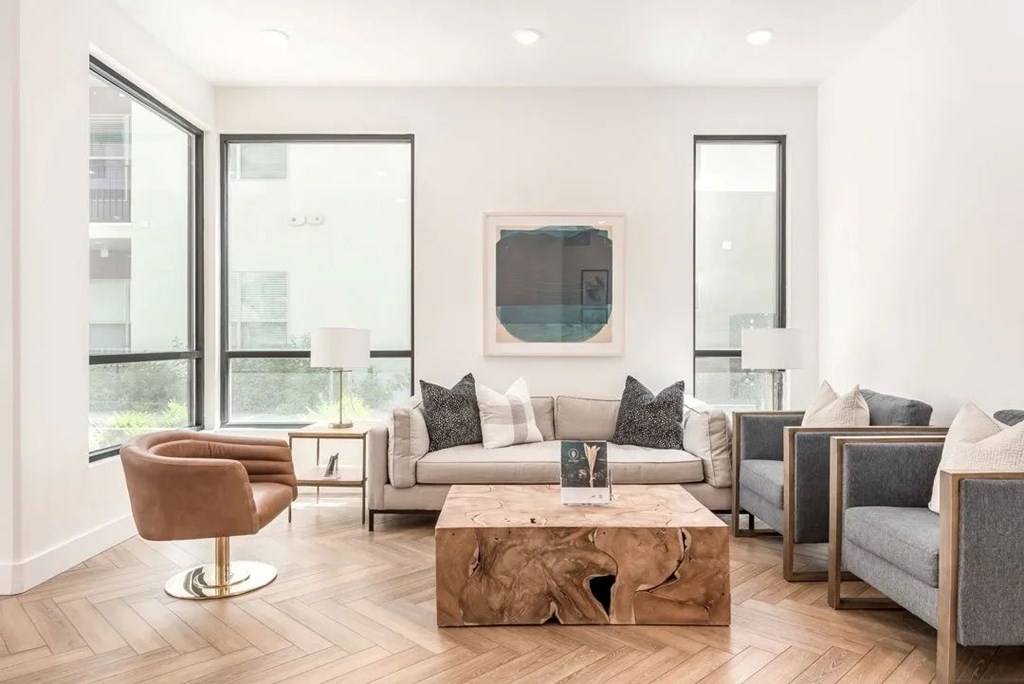 Alvera at the Meadows  living room with a wooden coffee table and a grey sofa.