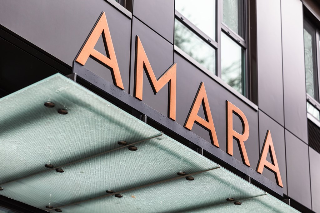 A sign with the word "AMARA" in orange letters is mounted on a building.