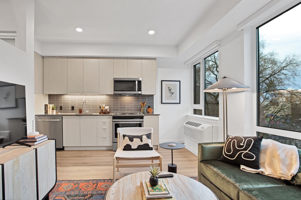 A modern kitchen with a dining table and a couch.