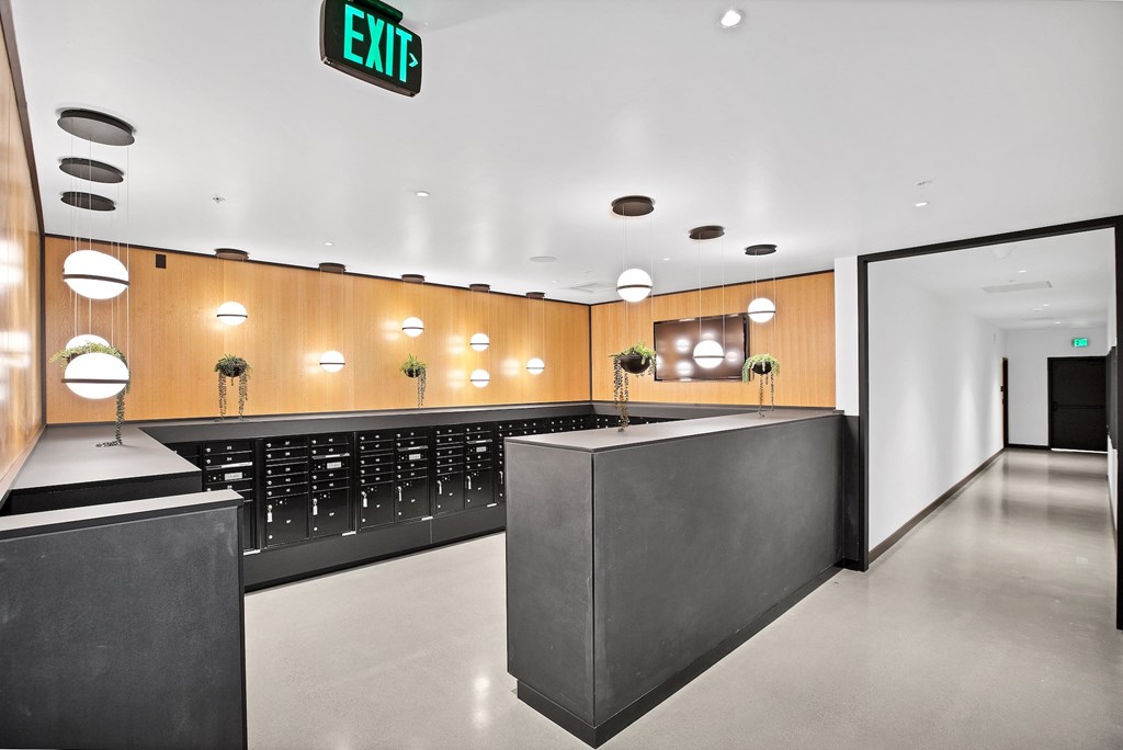 A modern interior with a black and wood design and a green exit sign.