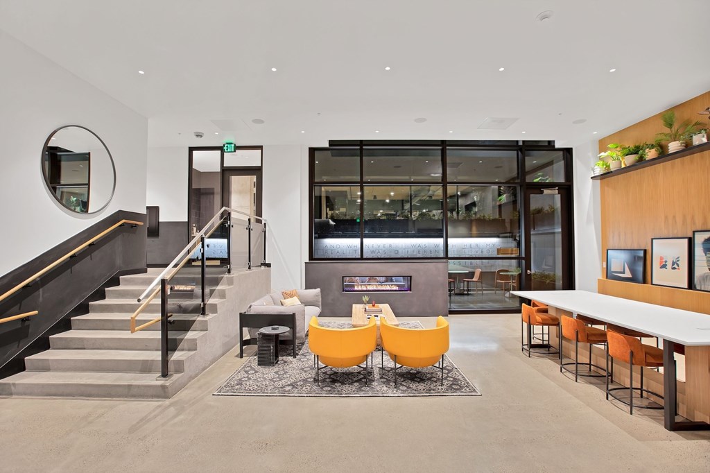 A modern interior with a staircase, seating area, and a bar.