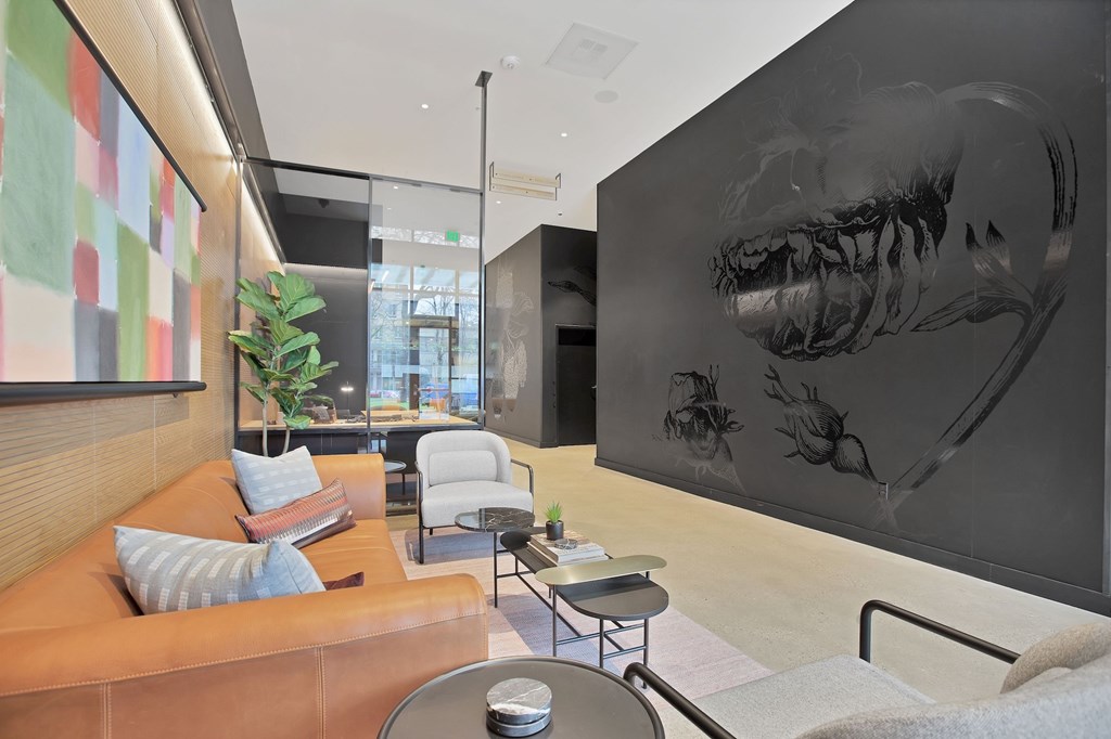 A living room with a brown couch and a large black and white dinosaur print on the wall.