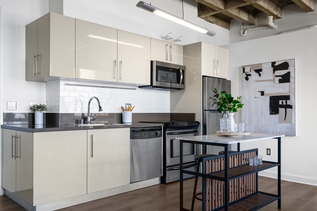 a kitchen with white cabinets and a counter with a table and chairs