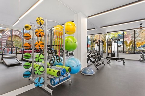 A gym with a variety of equipment including a rowing machine, a treadmill, and a stationary bike.