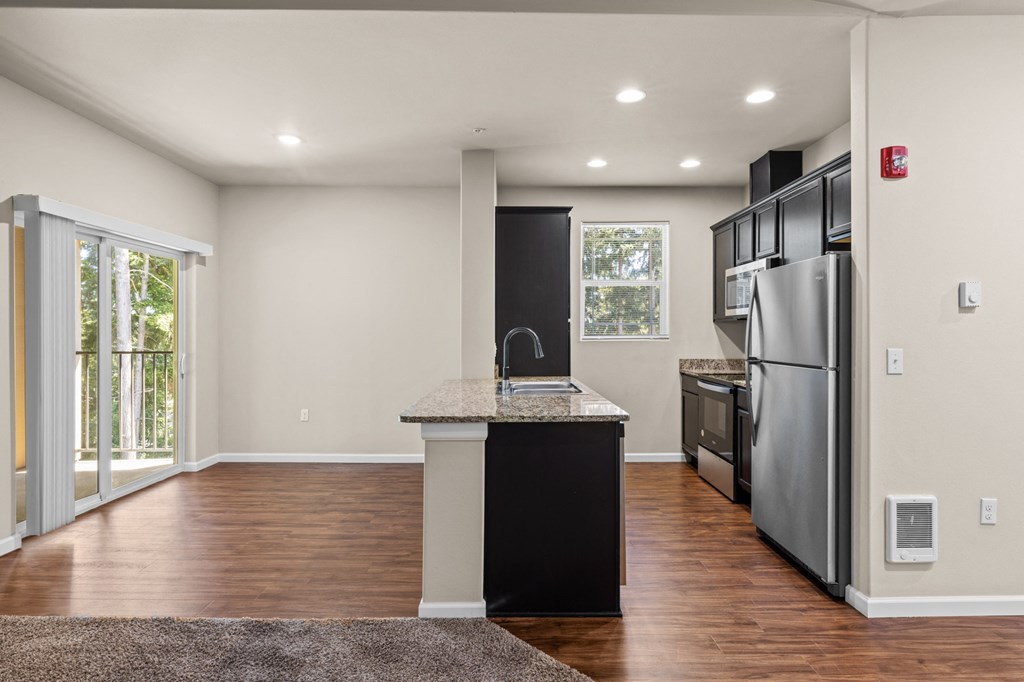 an empty kitchen with stainless steel appliances and a counter top