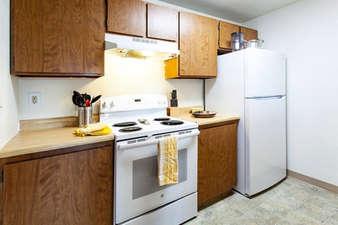 a kitchen with white appliances and wooden cabinets