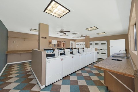 A kitchen showroom with white appliances and a checkered floor.