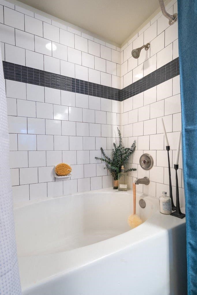 a white bath tub sitting next to a shower