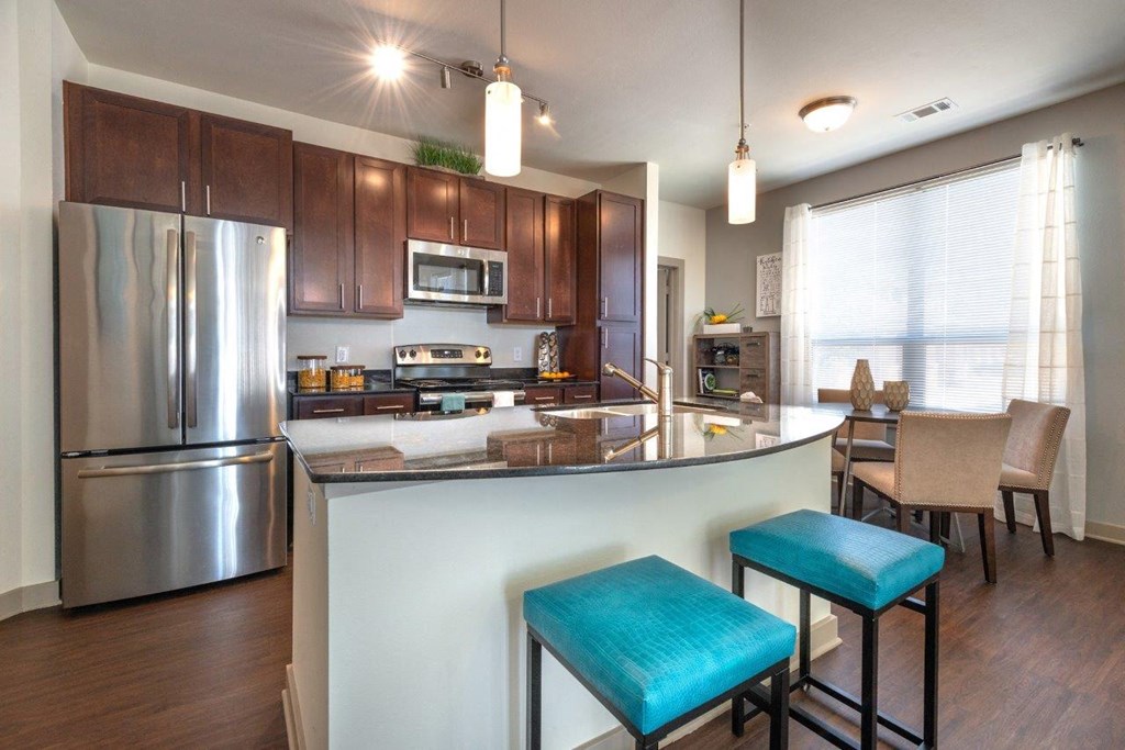 a kitchen with a large island with two stools in front of it