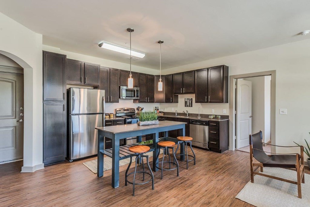 a kitchen with a long blue island with four stools