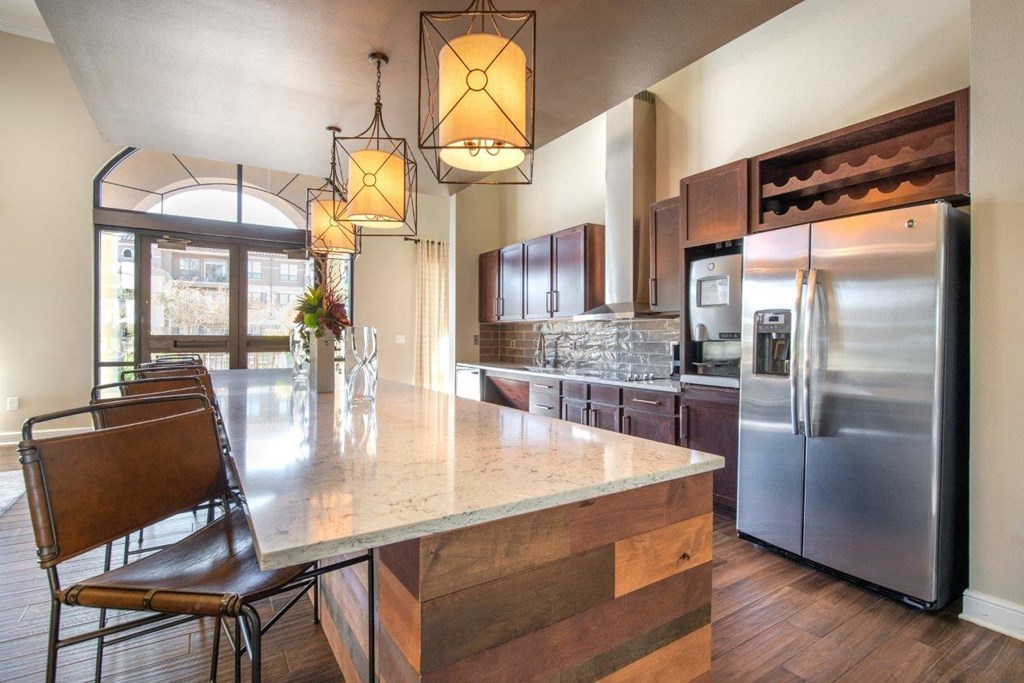 a kitchen with a large island and stainless steel appliances