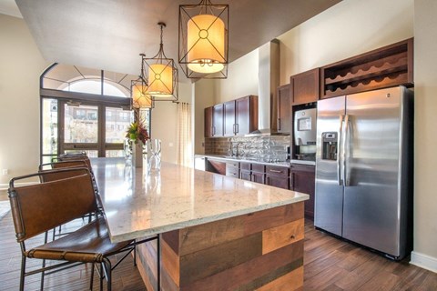 a kitchen with a large island and a stainless steel refrigerator