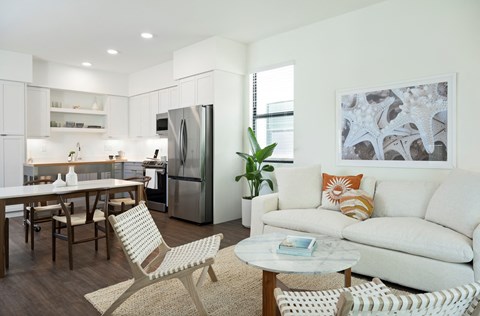 A modern living room with a white couch and a dining table.