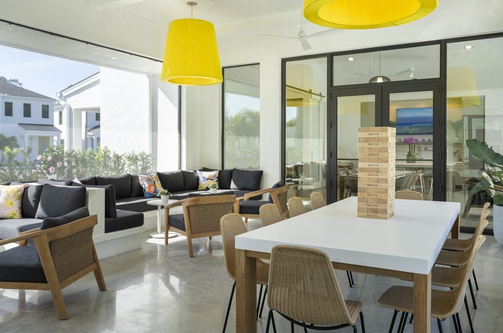 Argos by Soltura Rental Homes communal area with tables and chairs and yellow lights