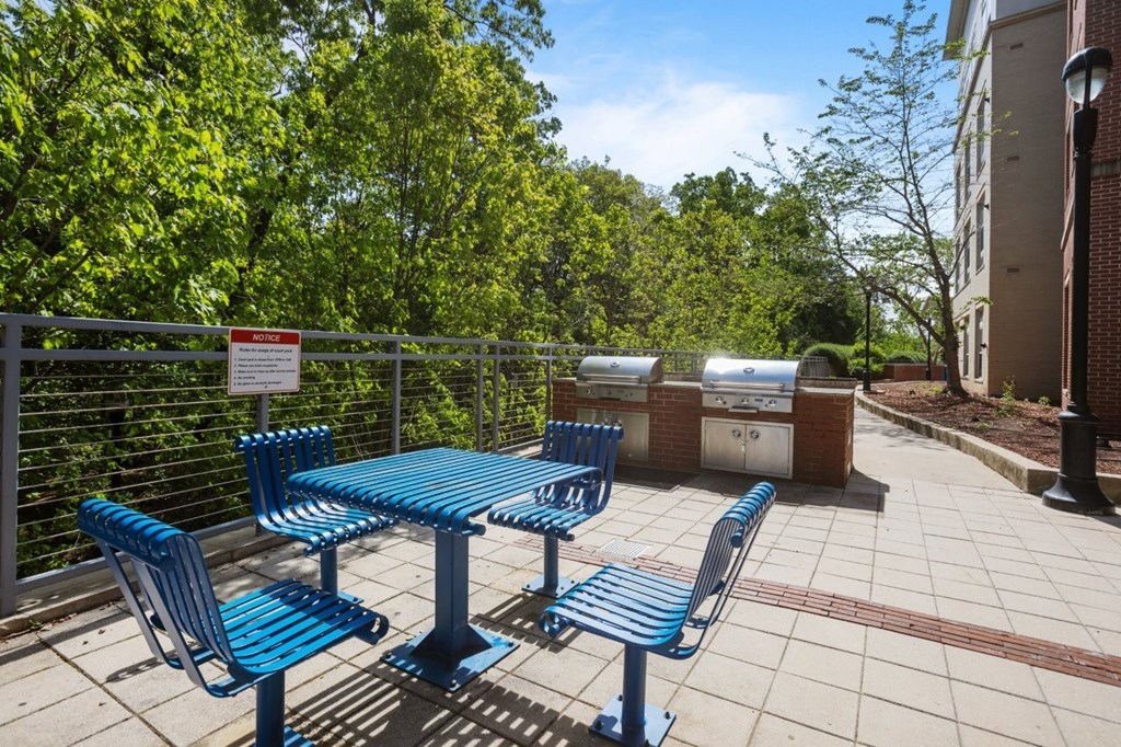 A blue table and chairs are set up on a patio.