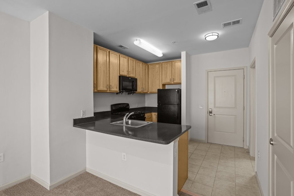 A kitchen with black countertops and white cabinets.