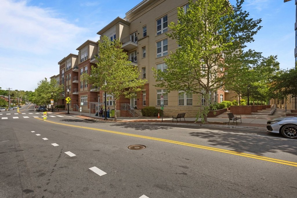 A street view of a residential area with apartment buildings on the side.