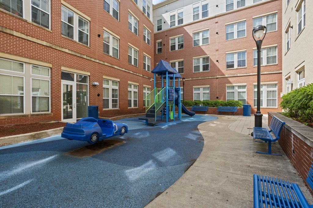 A playground with a blue slide and a blue car.