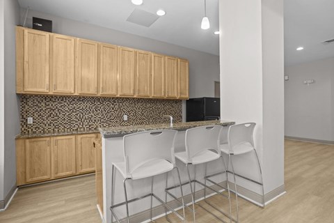 A kitchen with wooden cabinets and a black refrigerator.