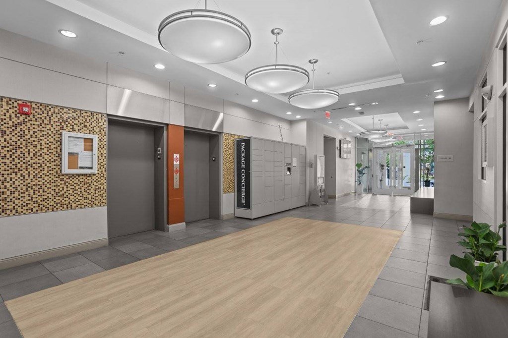 A hallway with a wooden floor and a patterned wallpapered wall.