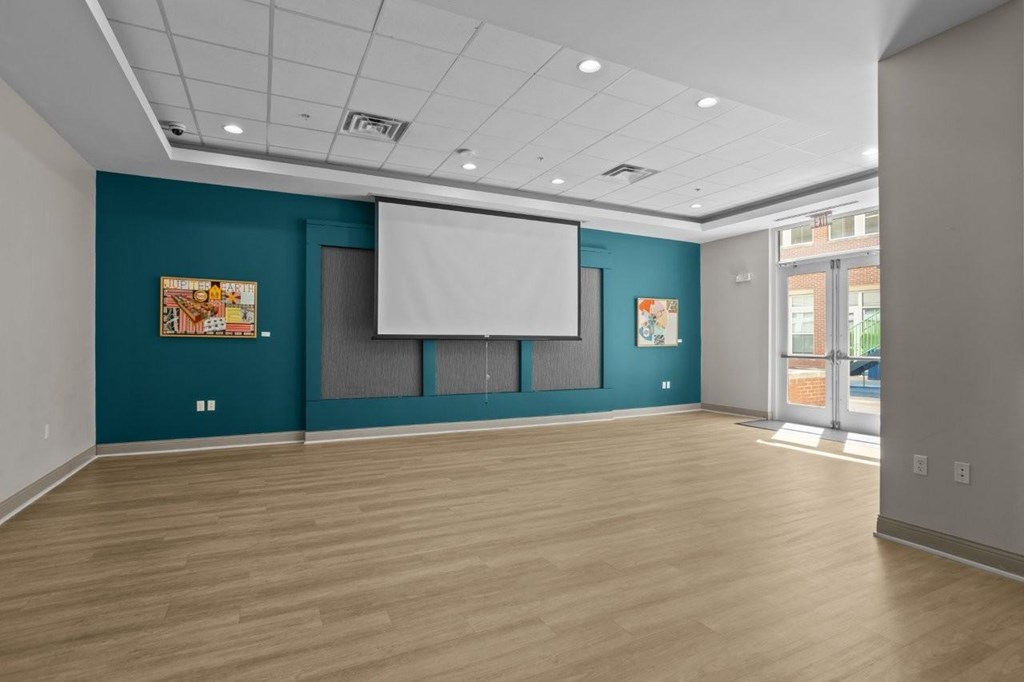 A room with a white screen and wooden floor.