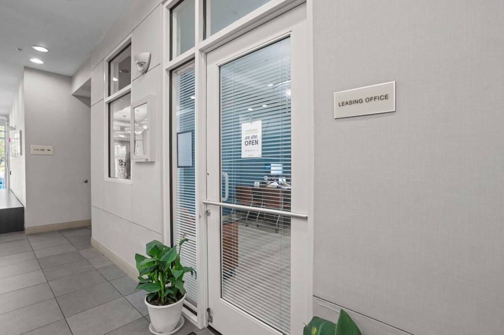 A sign on a wall says "Leasing Office" and is behind a glass door.