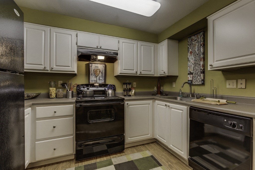 a kitchen with white cabinets and black appliances and a black stove