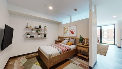 A bedroom with a bed, a TV, and a window.