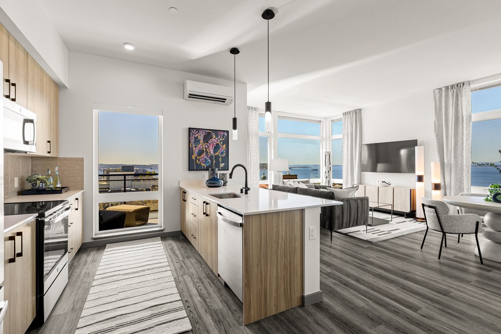 A modern kitchen with a large island and a view of the ocean.