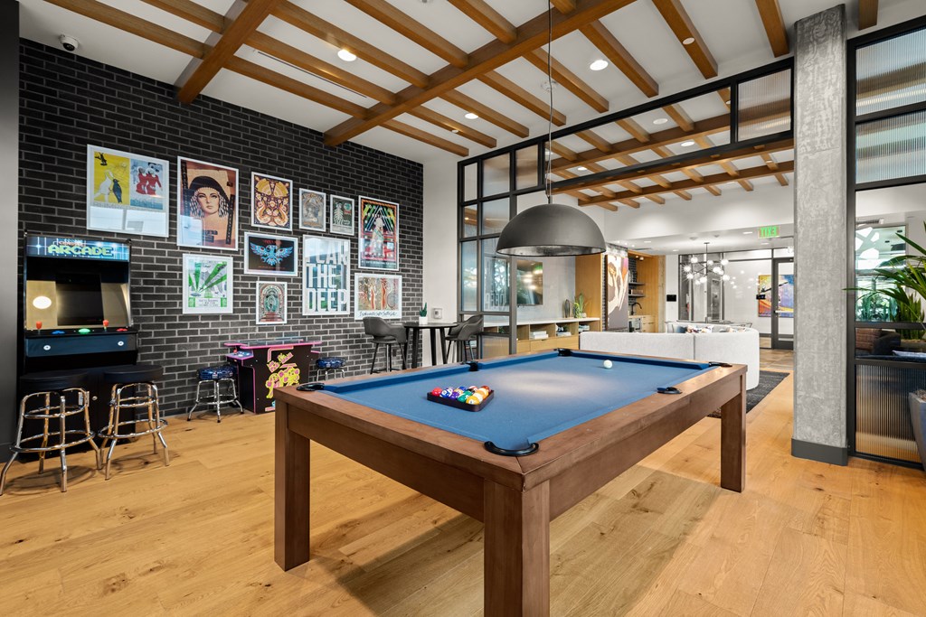 a pool table in a living room with a bar and a television