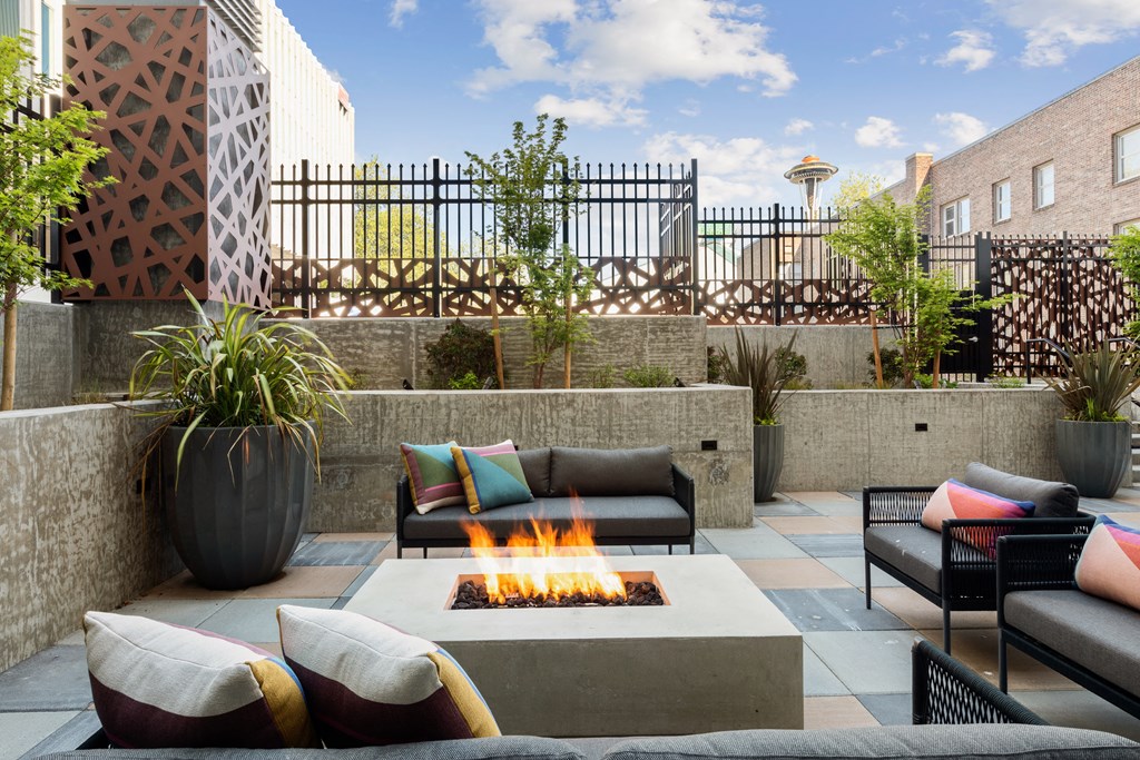a patio with couches and a fire pit