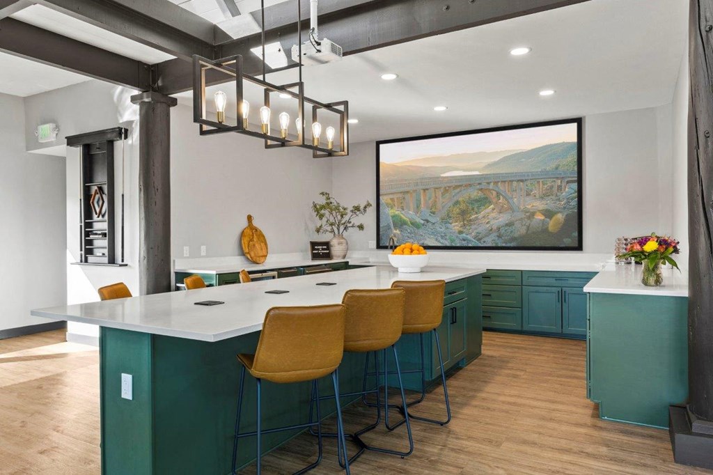 the kitchen has a large island and a large picture on the wall