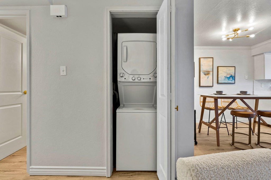 a white washer and dryer in a room next to a dining room table