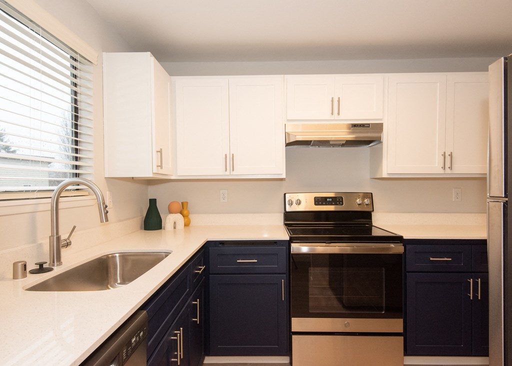 a kitchen with white countertops and blue cabinets