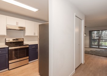 a kitchen with white cabinets and black appliances