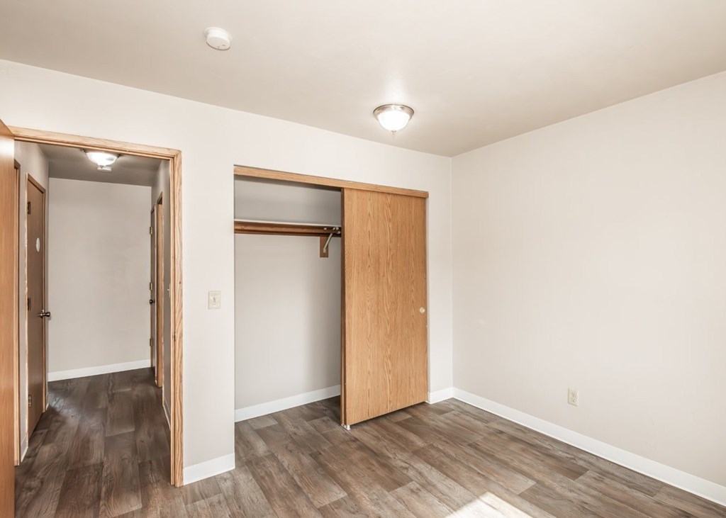 A room with a wooden floor and a white ceiling with a light fixture.