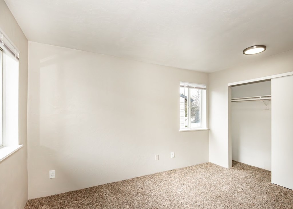 A room with a carpeted floor and a window.