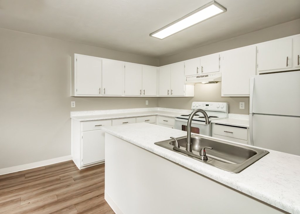 A kitchen with white cabinets and a sink.