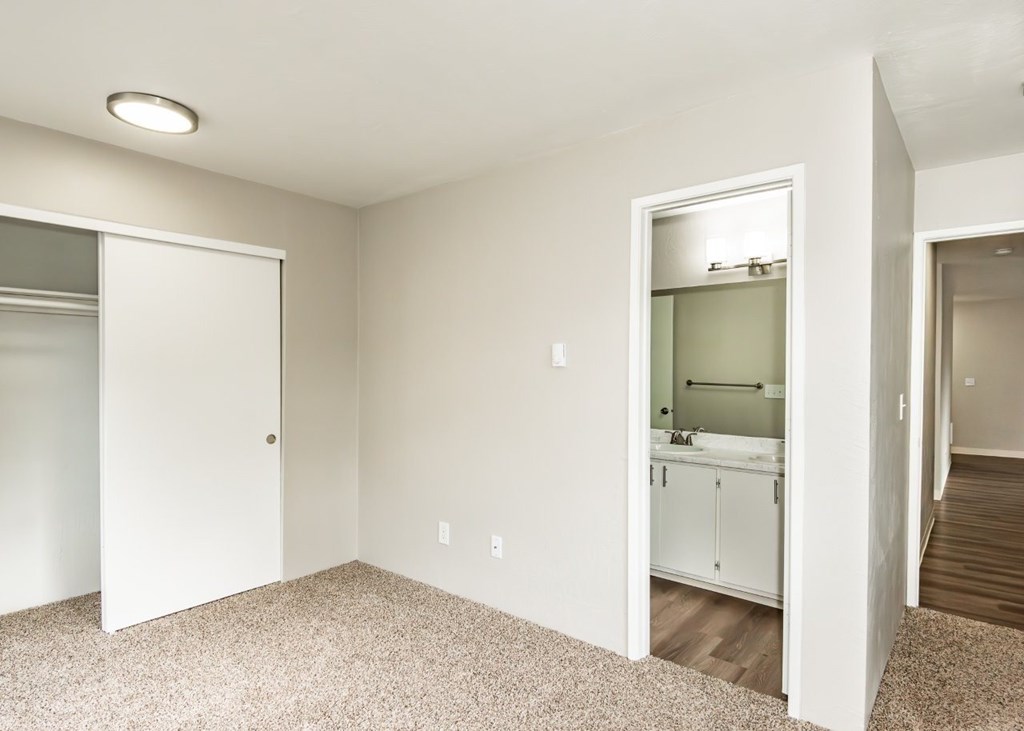 A white bathroom with a white door and a white cabinet.