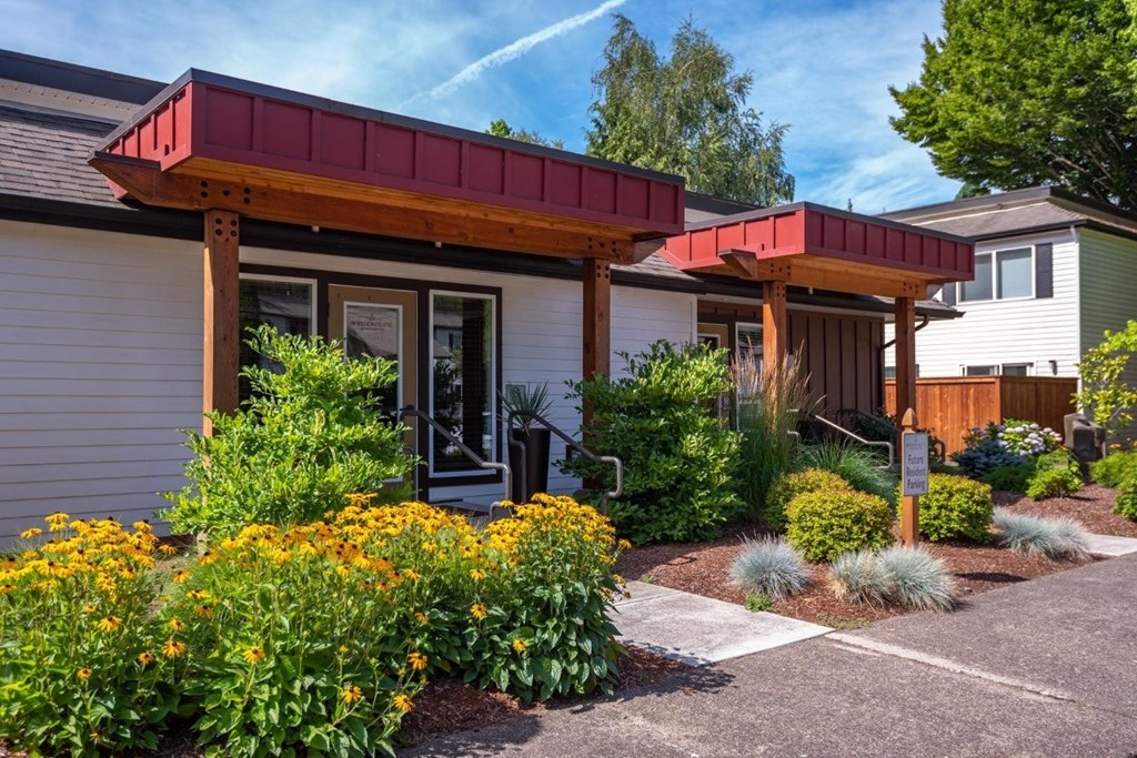 A house with a red roof and a garden in front.