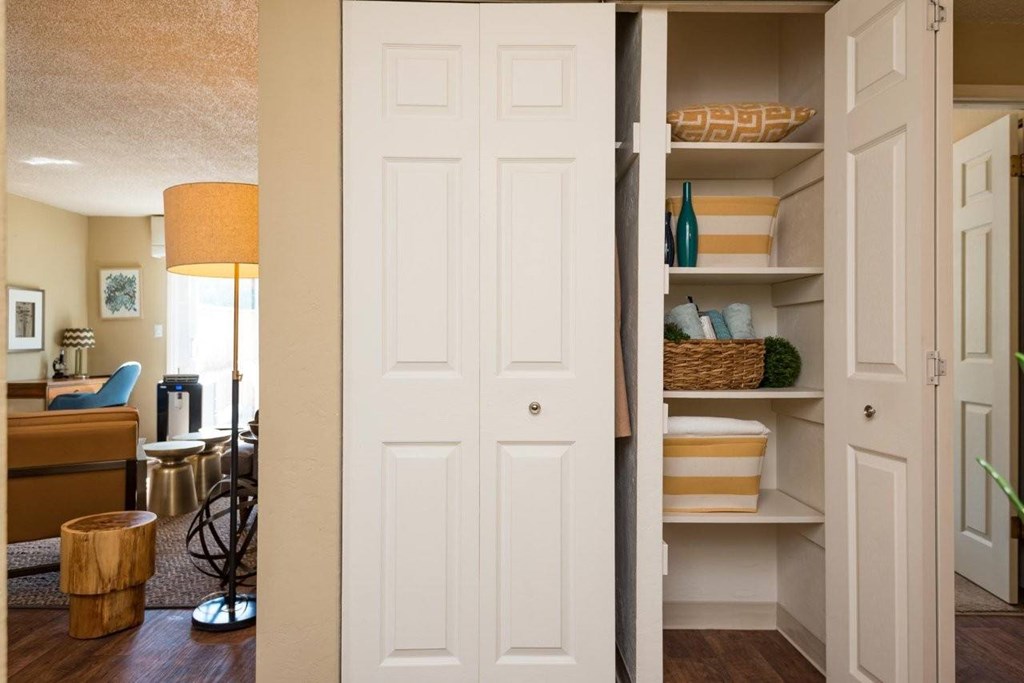 A white door is open to a hallway with a basket on the shelf.