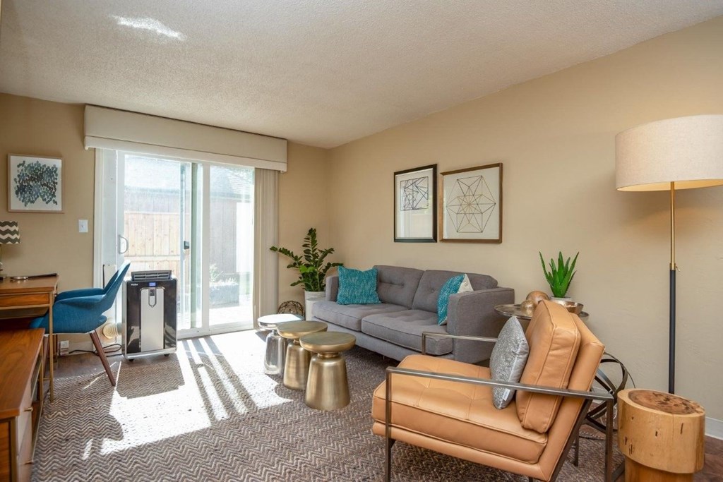 A living room with a grey couch, a blue chair, a wooden table, and a lamp.