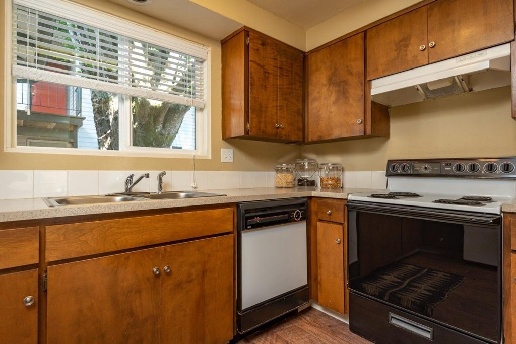A kitchen with wooden cabinets and a stove top oven.
