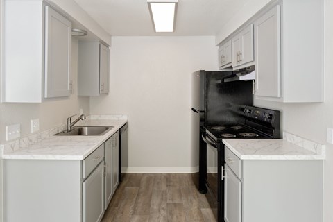 A kitchen with white cabinets and a black stove top oven.